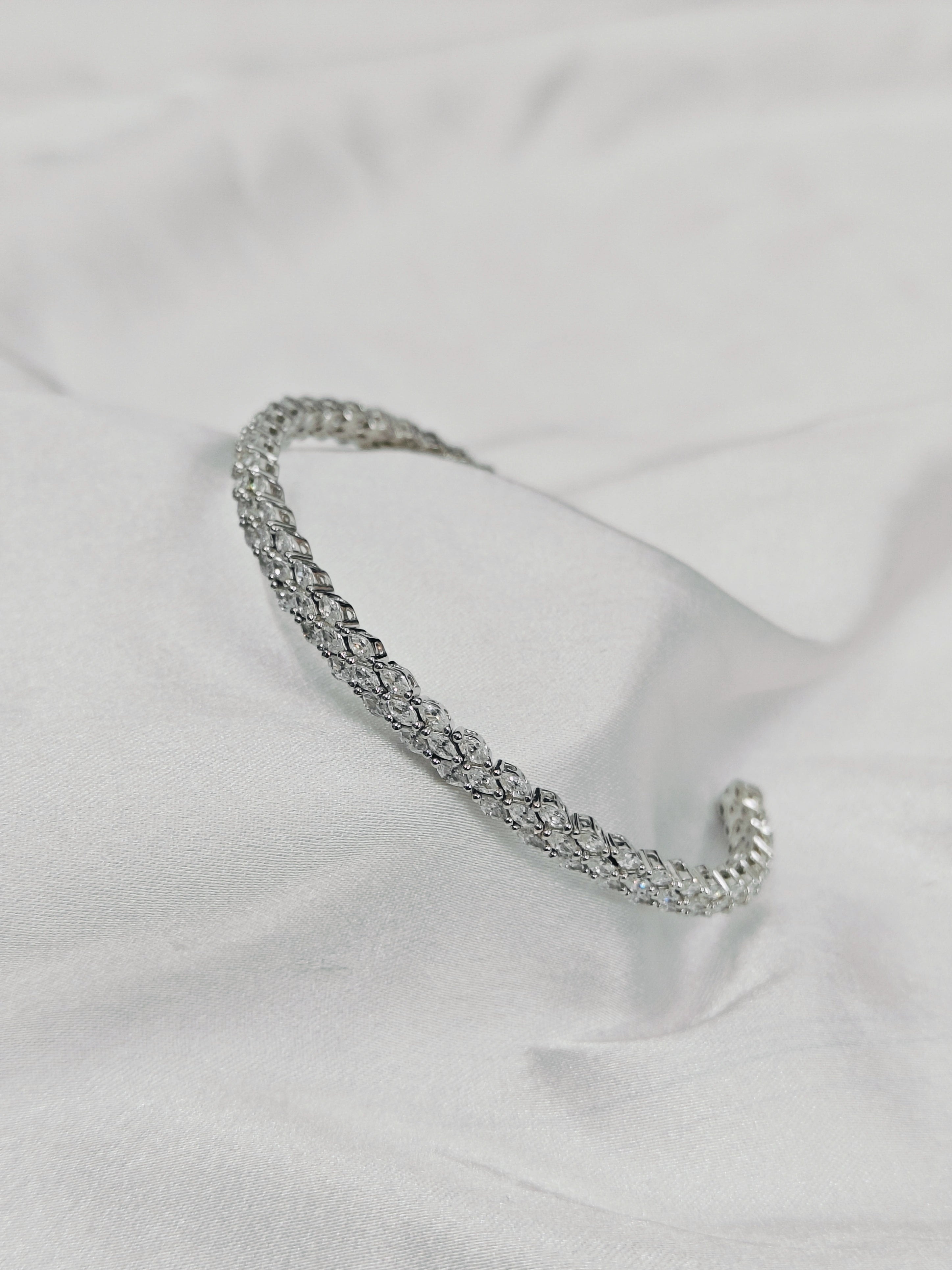 Silver bracelet on a light fabric background